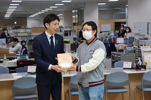 市長から赤ちゃんのお父さんに積み木の贈呈